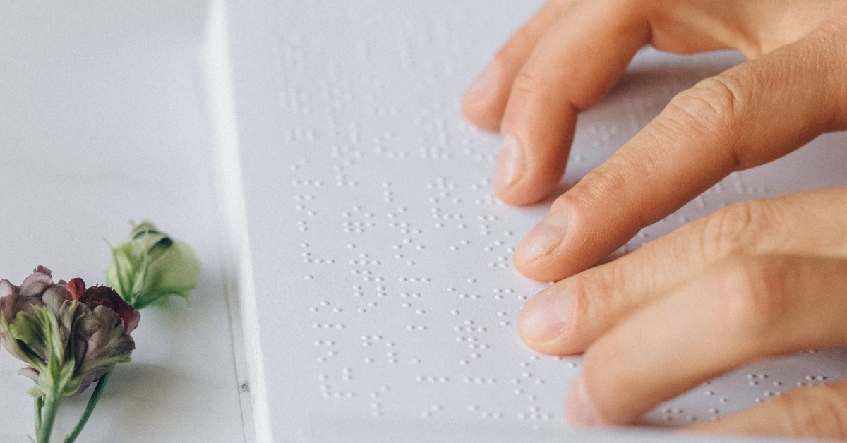 Pessoa efetua a leitura num livro escrito em Braille