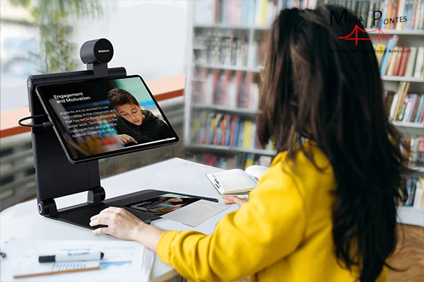 Senhora visualiza o conteúdo de um folheto com texto sobre imagem