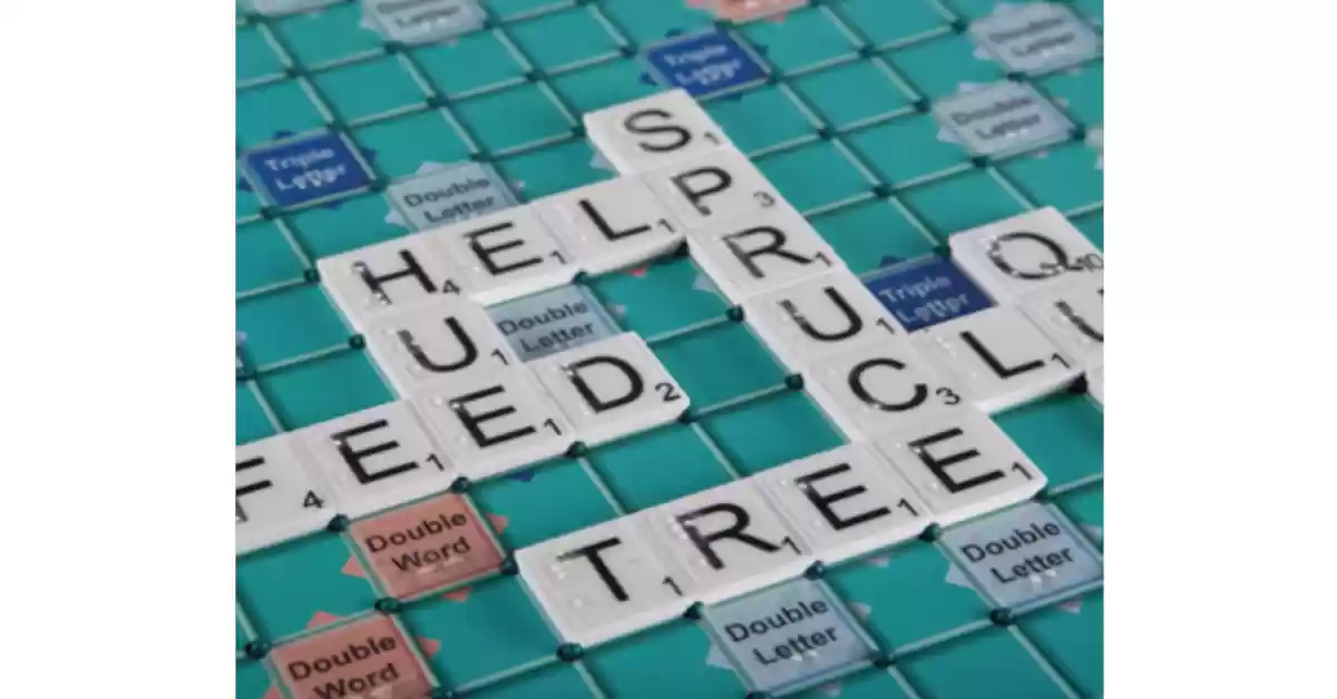 Jogo Scrabble com tabuleiro verde de cores contrastantes e peças brancas com letra preta ampliada.