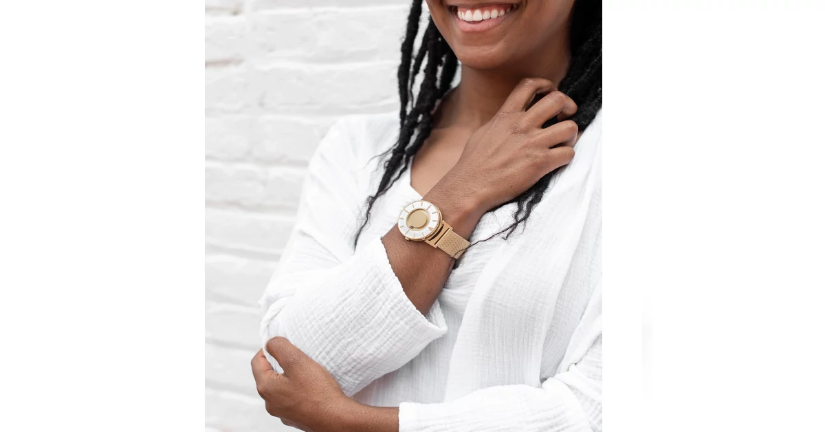 Senhora a sorrir com a mão no cabelo a usar o Bradley