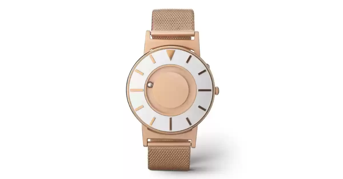 Relógio táctil com mostrador em aço e bracelete em malha dourada rosa, esferas indicam as horas.