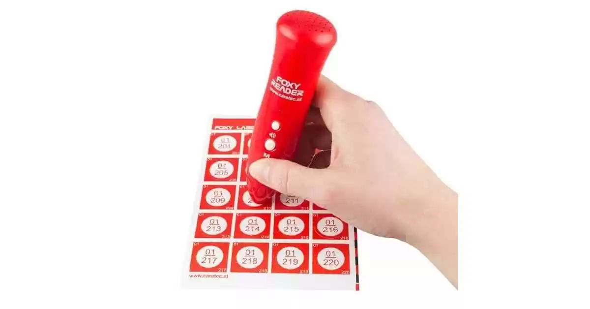 Leitor de Etiquetas com Voz Portuguesa FoxyReader vermelho sobre uma folha de etiquetas autocolantes