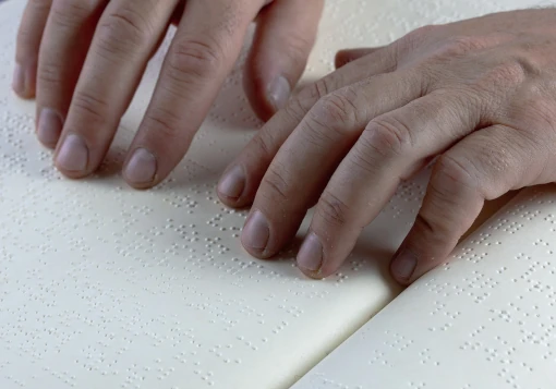 Pessoa a ler um livro impresso em Braille