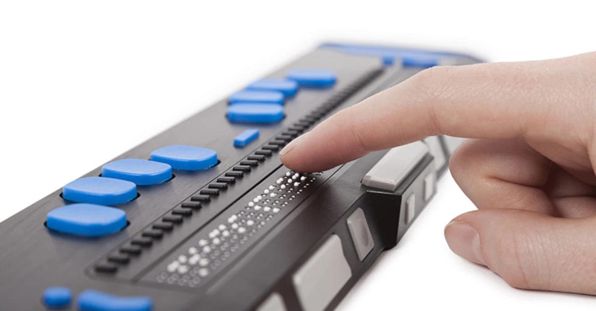 Cego a efetuar a leitura numa linha Braille portátil