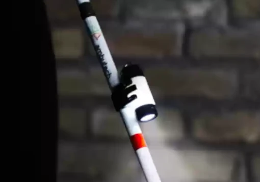 Lanterna ligada com luz branca brilhante instalada numa bengala branca. 