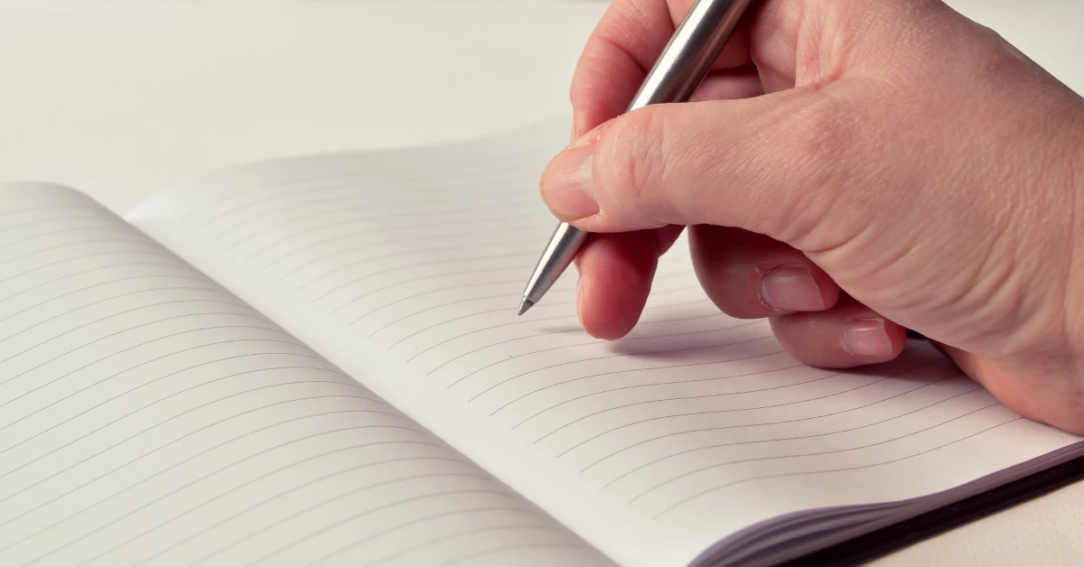 Pessoa a escrever no livro de visitas